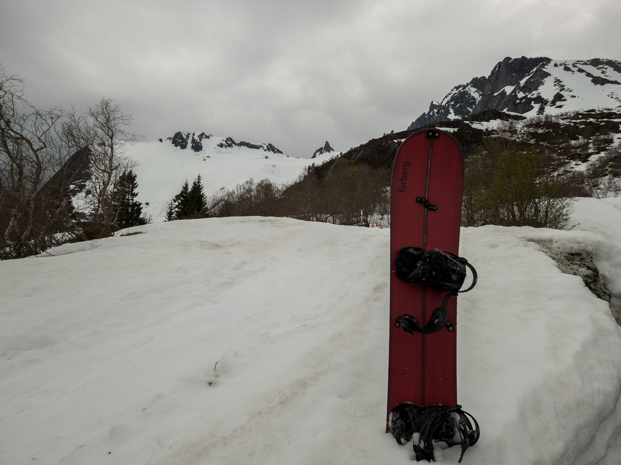 Et rødt splittbrett står i snøen med Fingeren og fjellsidene i bakgrunnen